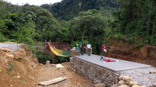 Students working on suspension footbridge high in the mountains of Bolivia
