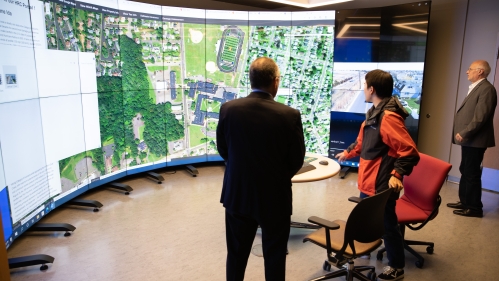 Professor and graduate student sharing mapping research on large circular screen