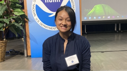 Female Asian college student wearing a navy blue dress and a name tag.