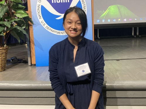 Female Asian college student wearing a navy blue dress and a name tag.