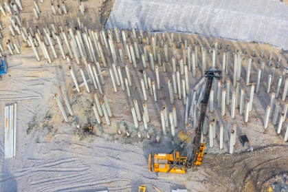 Equipment for installing piles in ground, heavy machines for driving pillars work in laying the foundation building. Construction aerial view height.