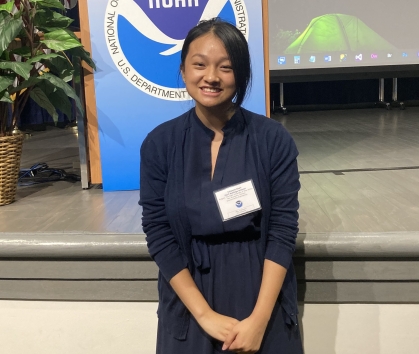 Female Asian college student wearing a navy blue dress and a name tag.